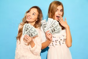 Studioul numarul 1 de videochat din iași 18 portrait two happy delighted blond women wearing summer clothes rejoicing win holding cash money isolated blue wall